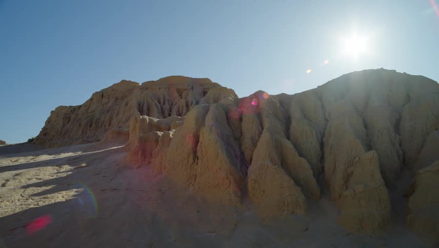 Sun shines over a rock formation in the desert
