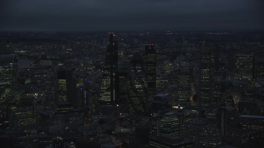 Aerial shot of illuminated skyscrapers and high rise buildings in the city at night