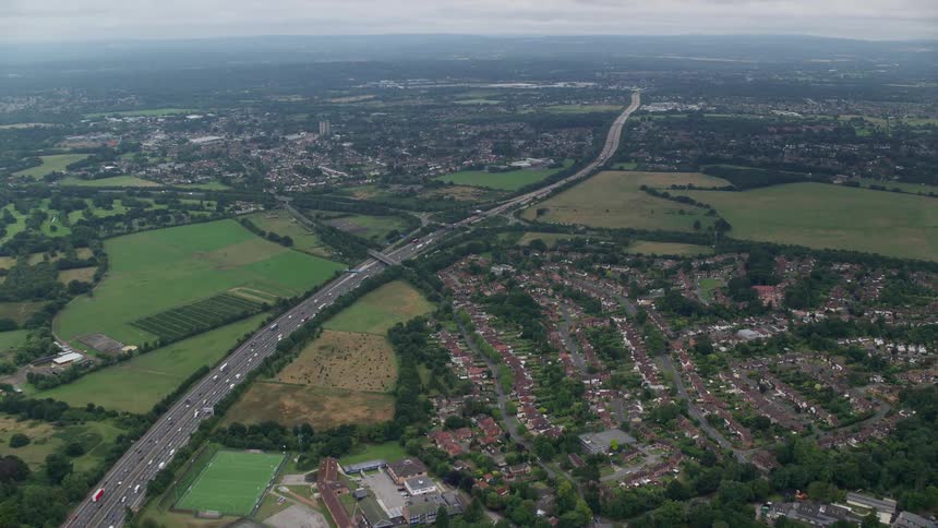 Traffic flows along highway passing residential neighborhoods