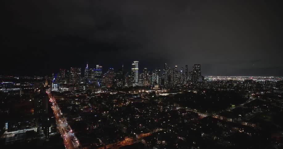 Aerial view of distant brilliantly illuminated skyscrapers in a sprawling cityscape