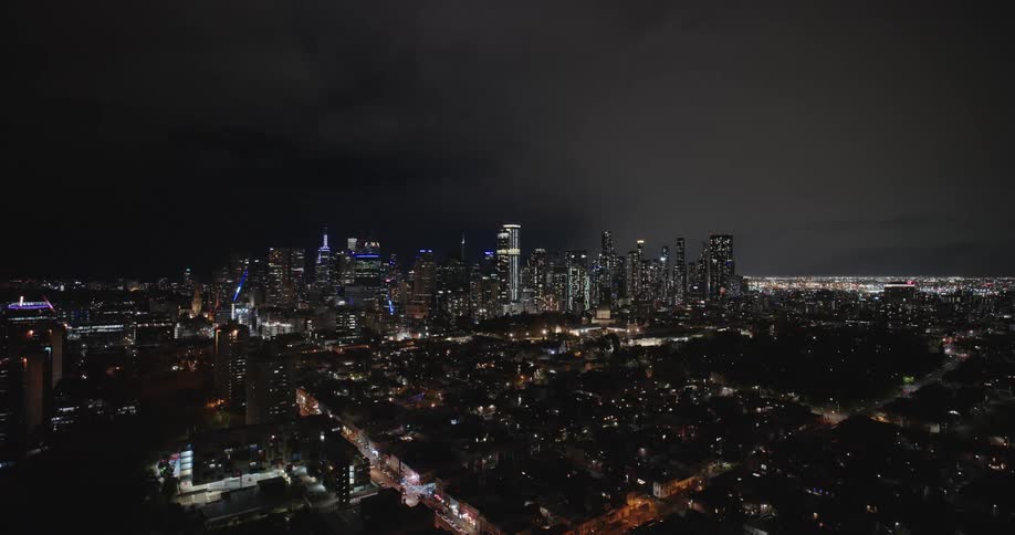 Aerial view of a metropolis with skyscrapers and houses at night