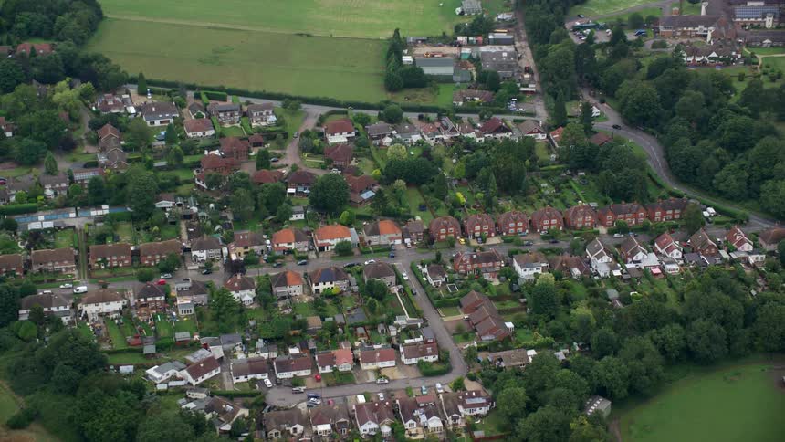 Aerial view of a small village surrounded by green fields and trees