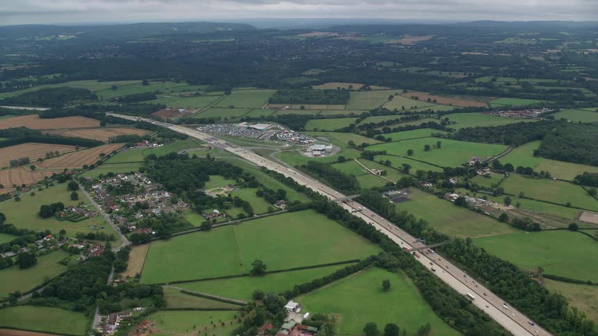 A rural area of a city with a huge highway with many vehicles passing by