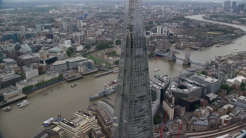 Aerial view of a metropolis on the edge of a river with emphasis on a massive mirrored skyscraper