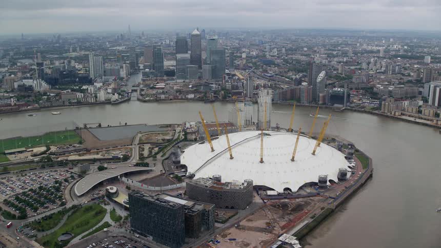 A building shaped like a dome next to a river dividing a large city