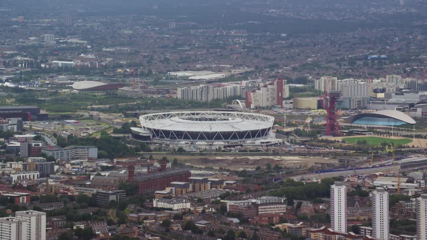 A large white stadium in a city with residential buildings