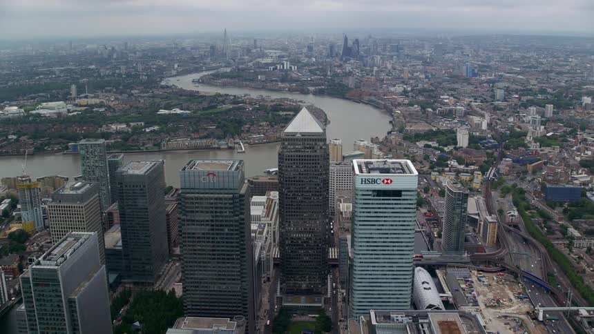 A huge river with curves crosses a city that has huge buildings