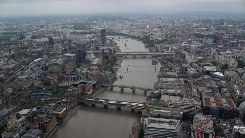 A huge river with several boats that passes through the middle of a huge city