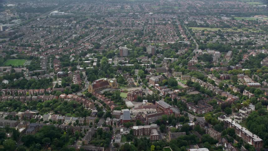 Aerial of buildings and trees in a suburban area at midday