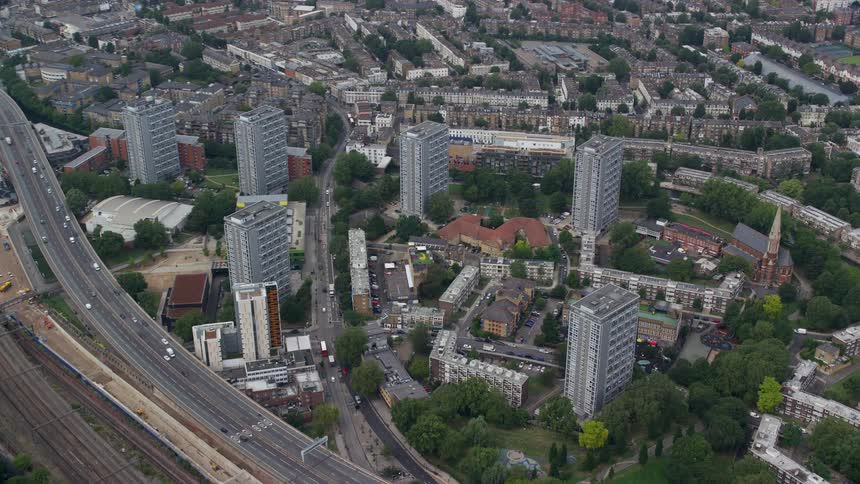 Aerial view of vehicles driving on highway near tall buildings in the city