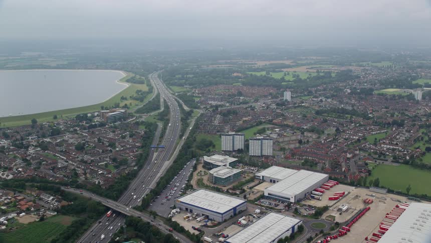 A huge road with many vehicles that passes through rural regions and suburbs of a city