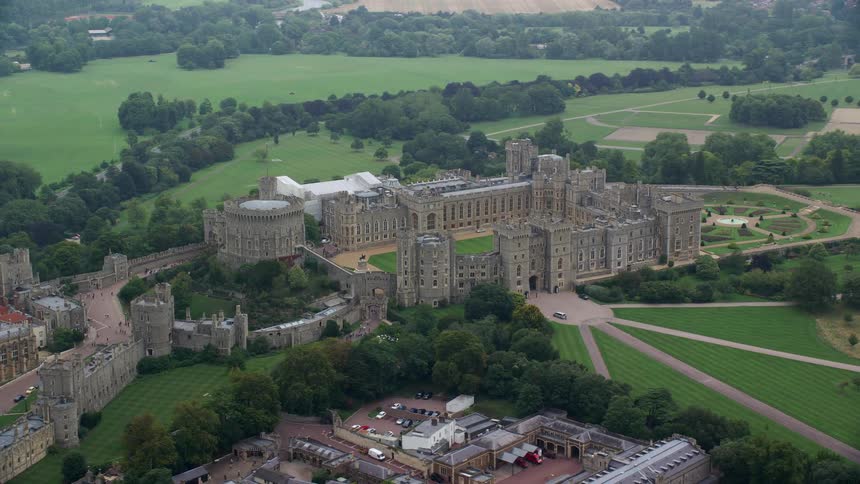 Aerial view of a castle surrounded by trees and vegetation in a sub urban area