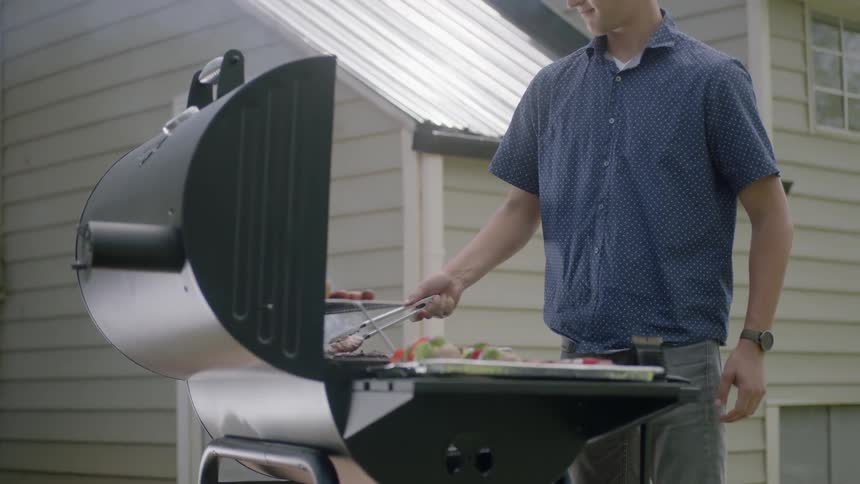 A man is cooking on a barbecue