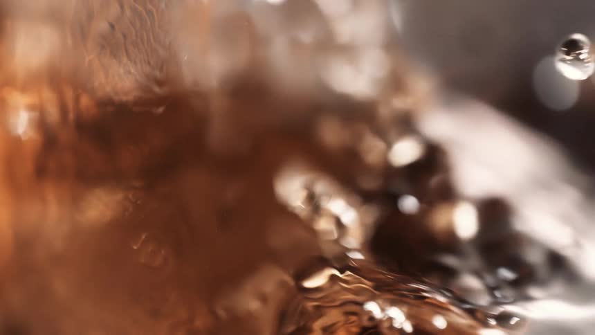 Amber beverage bubbles while filling glass