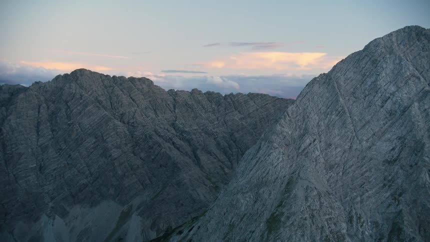 Aerial of stone mountains with patchy vegetation on the bottom slopes