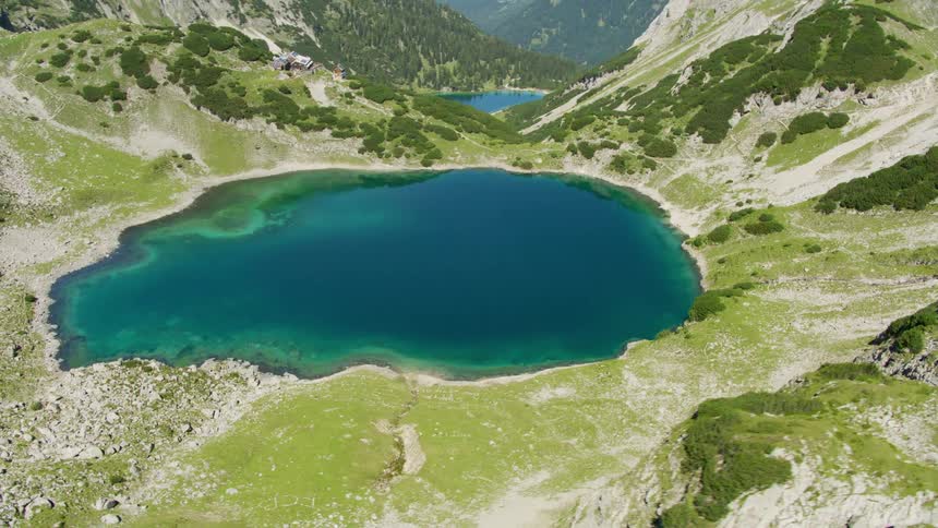 Aerial view of a turquoise blue lake amidst the mountains