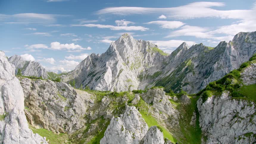 Series of mountains in the summer as green grasses slowly covers them with rough edges