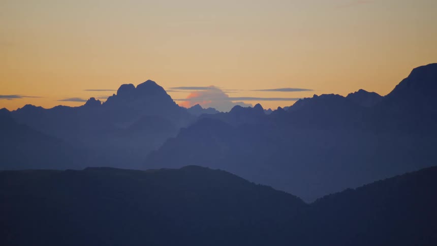 A region with high mountains and a sky with the setting sun