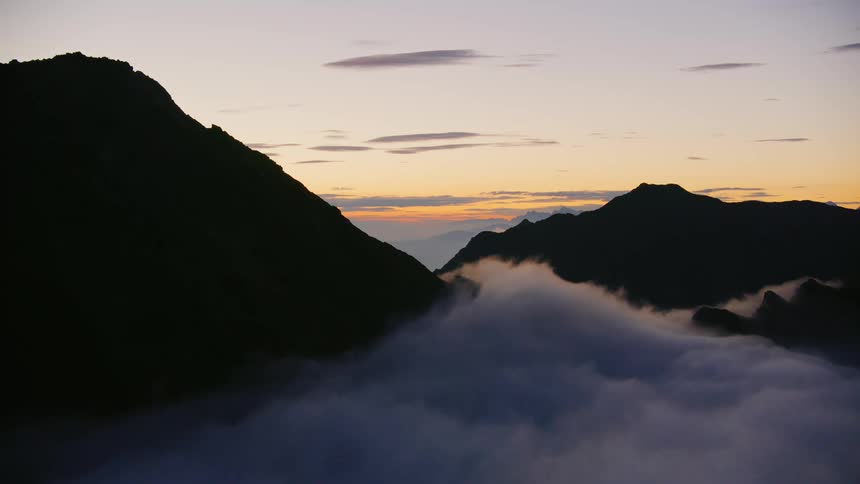 Rolling cloud cover near mountain peaks and ridges at sunset