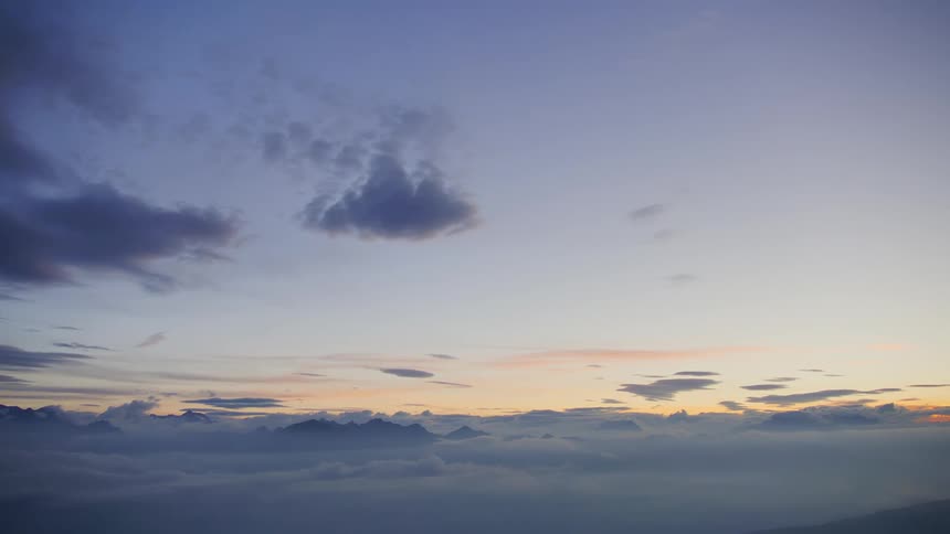 A gold and blue sky above dense cloud cover