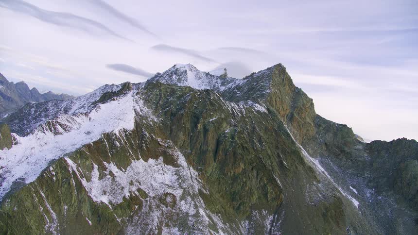 Aerial of snow dusted mountains on a cloudy day