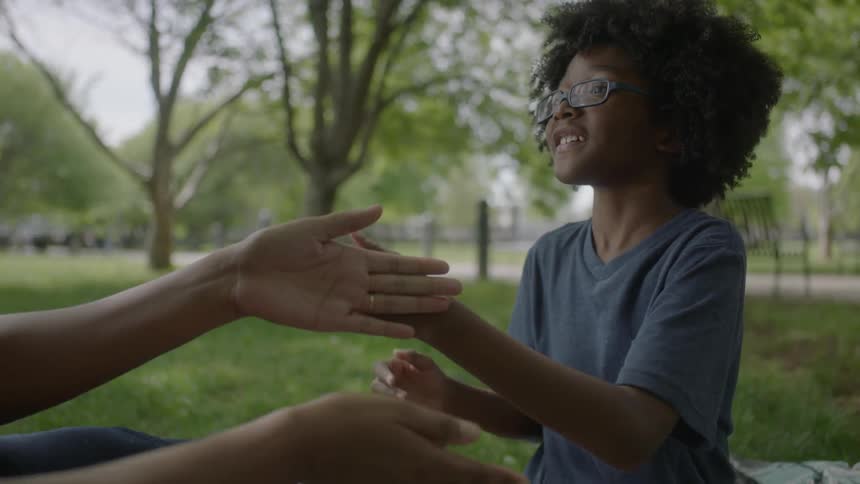 A child and person are playing a game with their hands