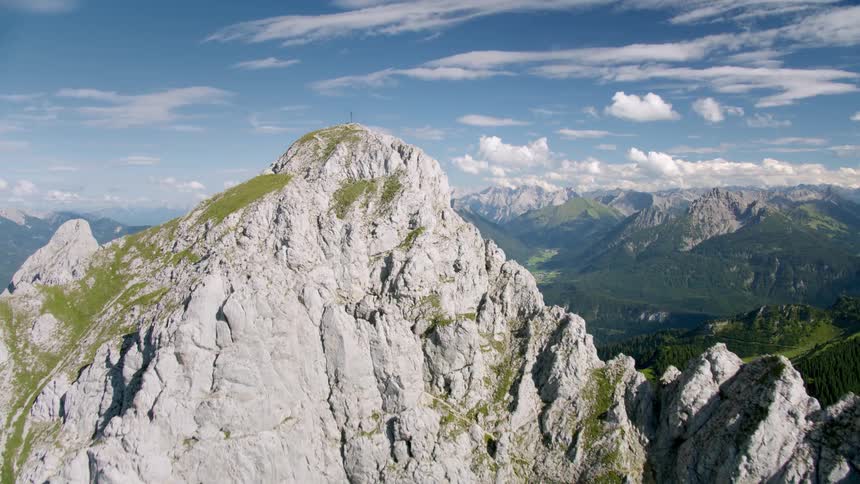 Aerial view of a mountainous landscape with cliffs and in the horizon a village