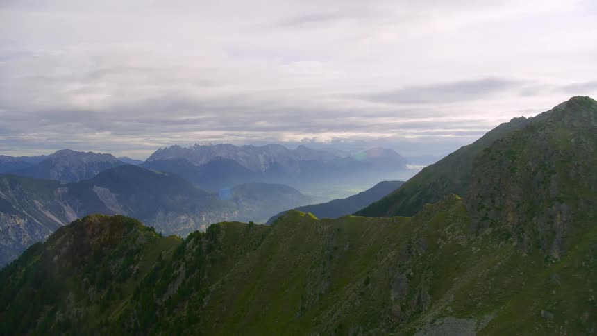 Aerial landscape of a mountain range with a village on the horizon