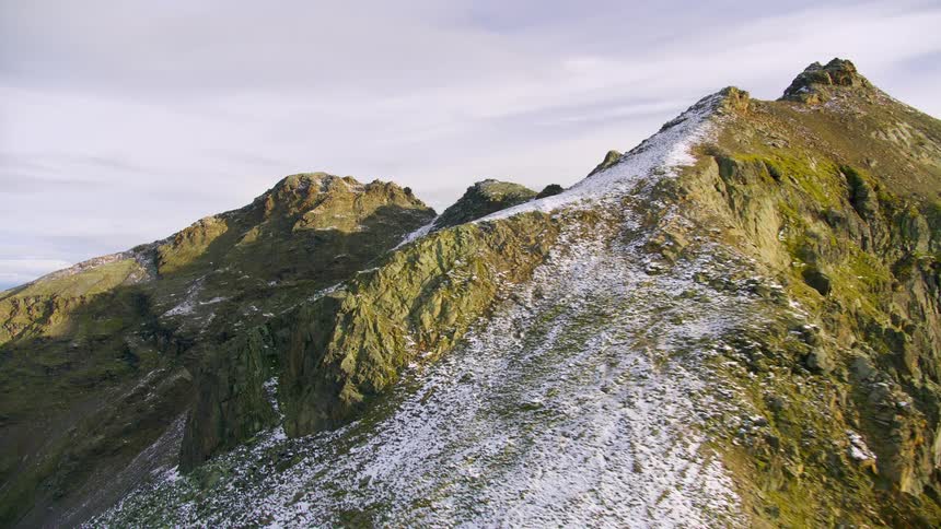 The green mountains are covered in frost