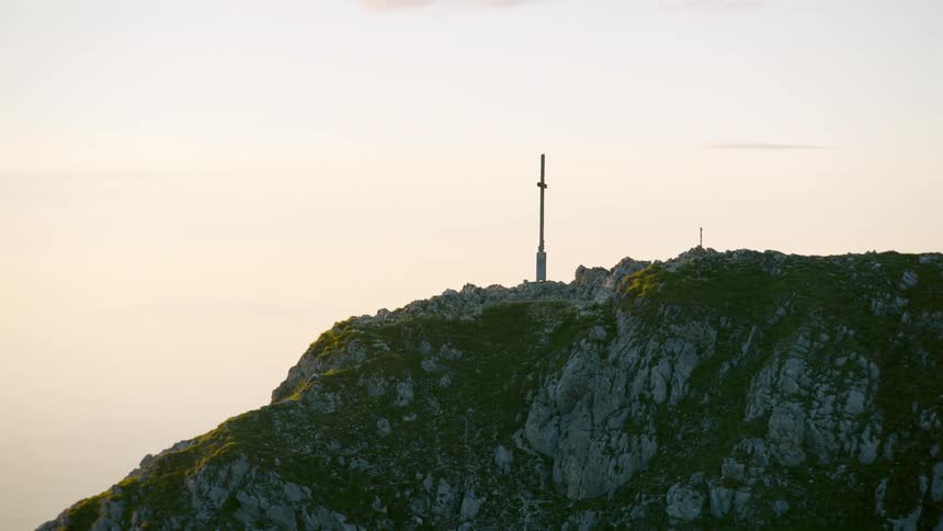 A cross on top of a hill made of a huge rock
