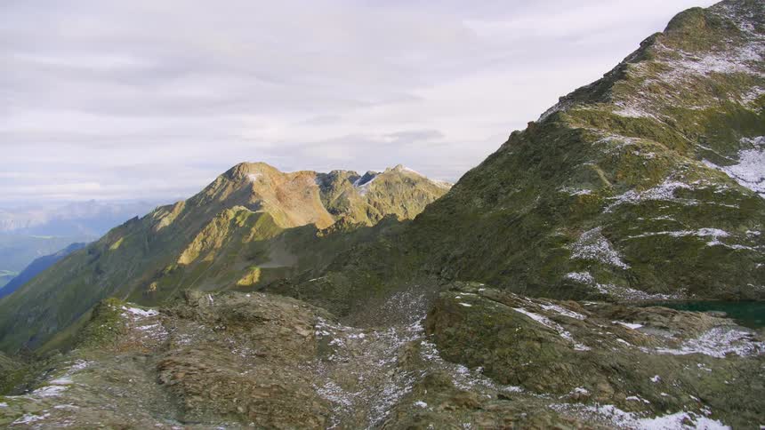 A few small lakes occupy snow dusted mountainous terrain