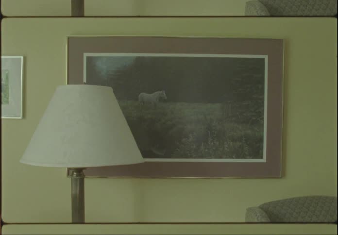 A picture frame hangs on the yellow wall