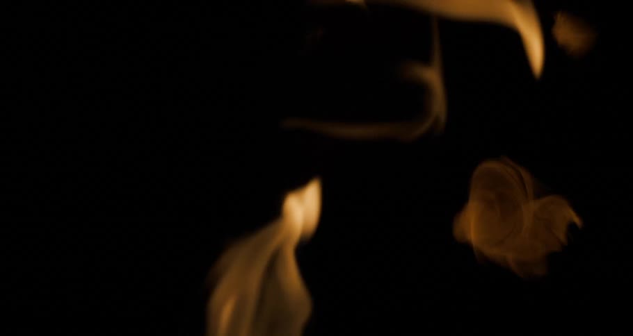 Orange flames rise through darkness