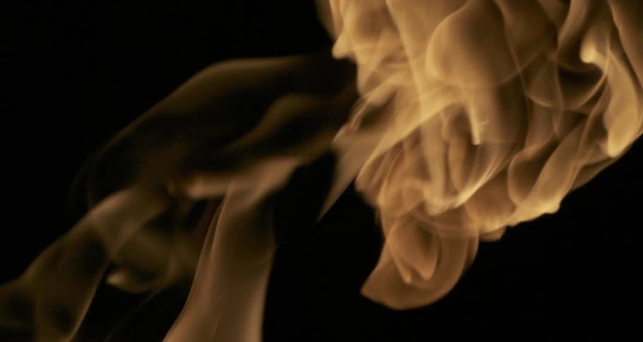 Glowing flames bend and twist as they rise in the darkness