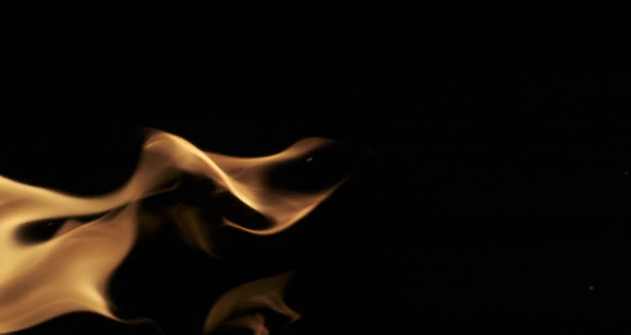 Glowing embers rise from orange flames as they float and twist across the darkness