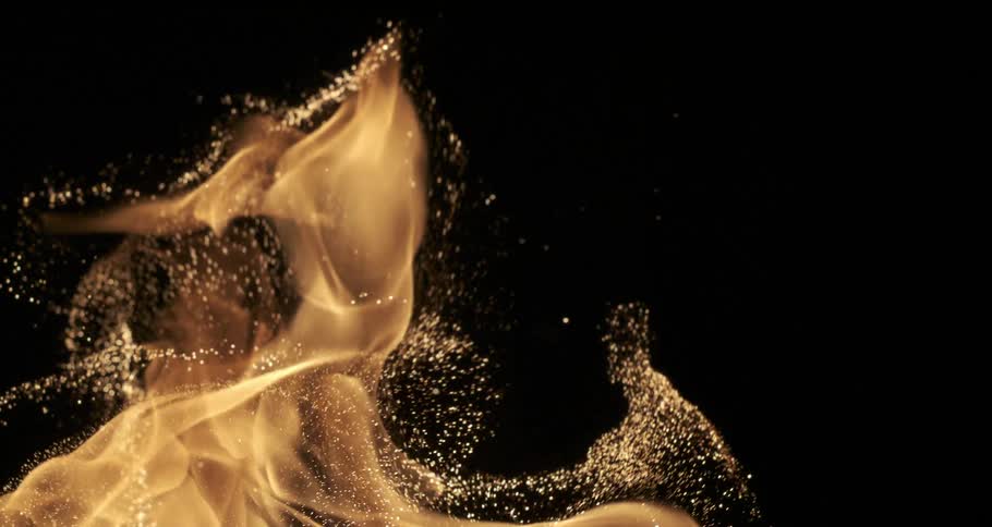 A yellow flame burning in a dark environment while dropping sparks