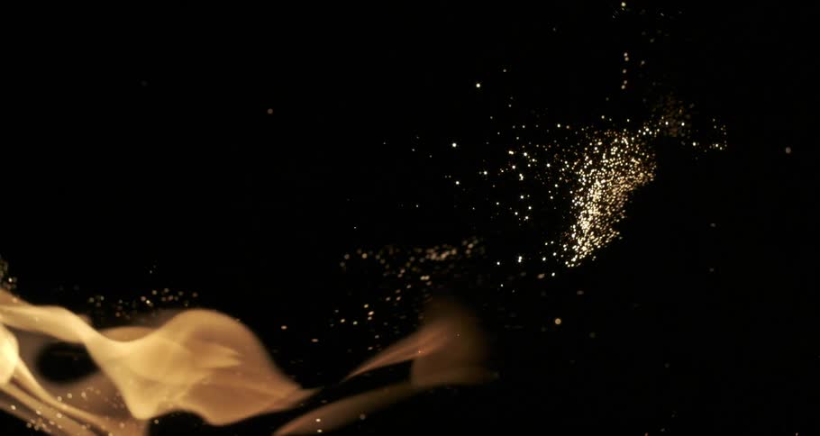 Glowing embers emerge from orange flames as they float across the darkness