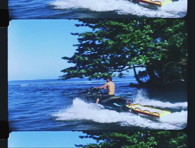 A man driving a watercraft heading towards the ocean