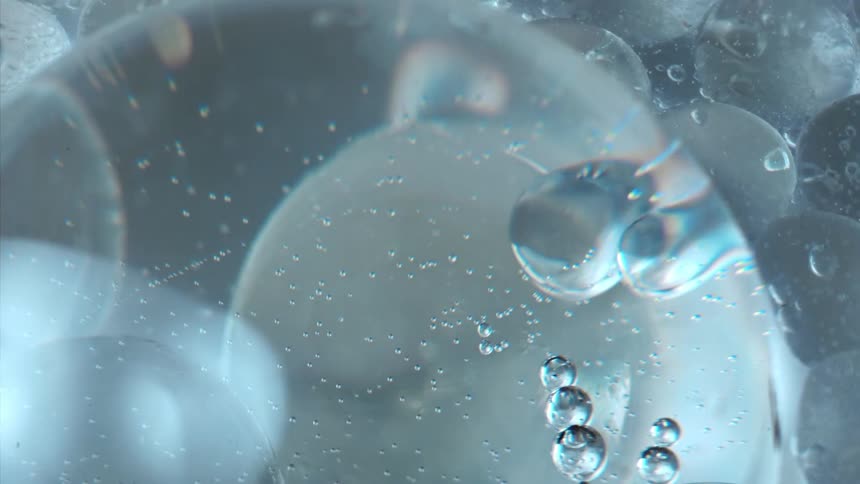 Light reflects on water droplets as they float and move