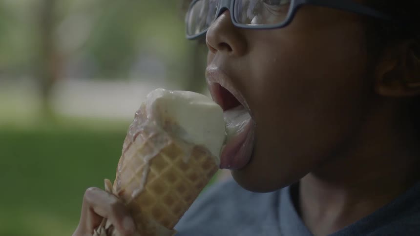 A boy licks an ice cream cone