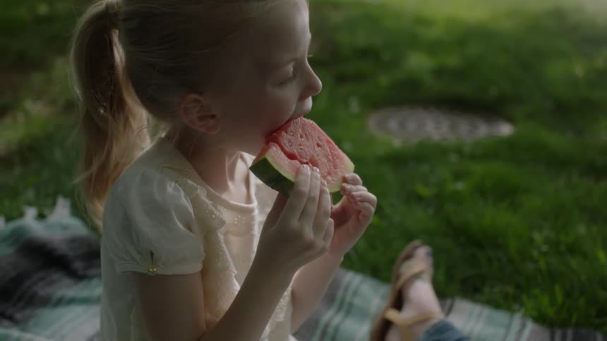 A girl is eating watermelon