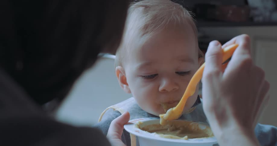 A mother is feeding her baby