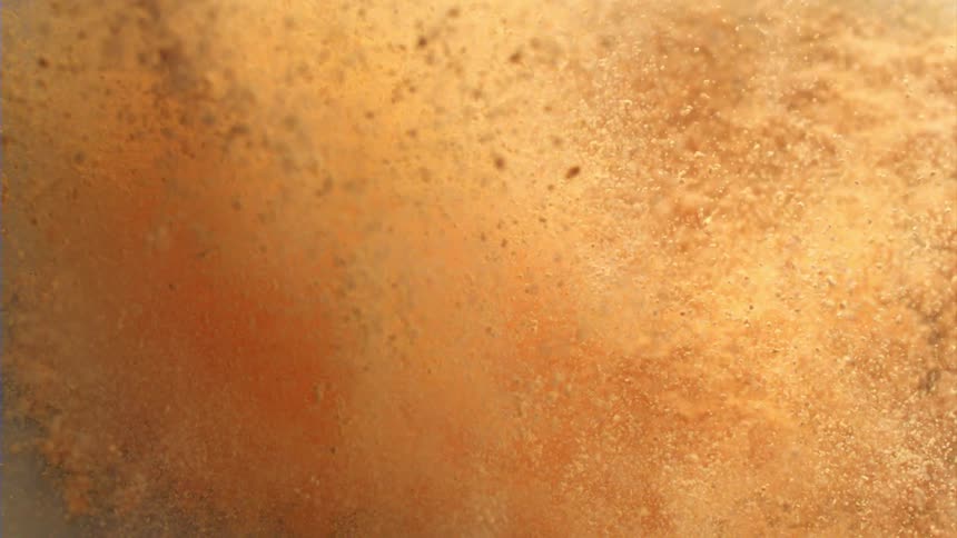 A plethora of beach sand chaotically explodes into the air