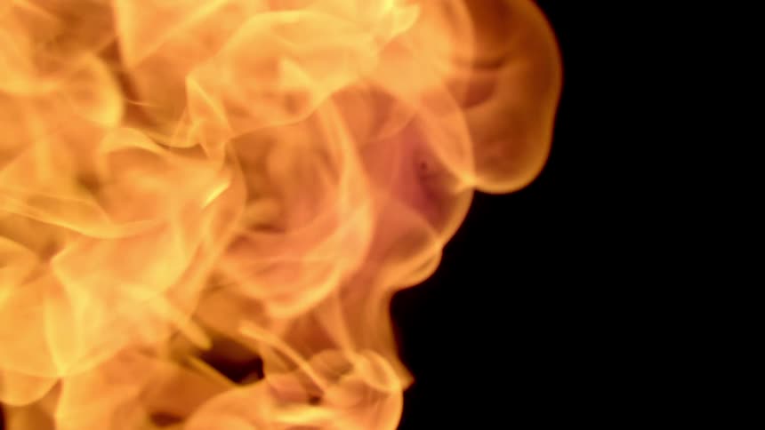 A burning flame of fire blurred on a black background