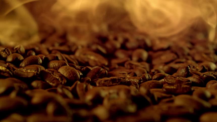 A huge pile of coffee beans has smoke emitting from it