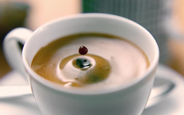 Closeup of a drop falling into a cappuccino cup