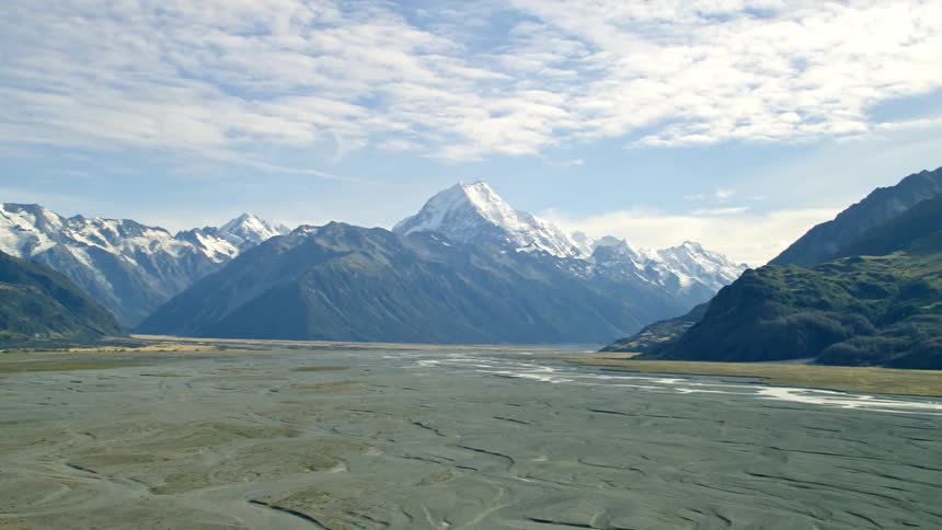 Snow topped mountains sit underneath blue skies