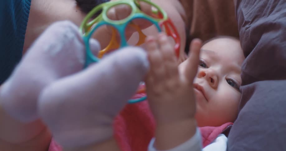 A mother kissing her baby while playing