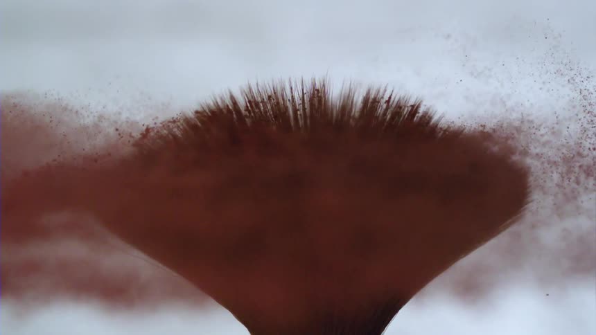 Make up brush spins spilling out red powder