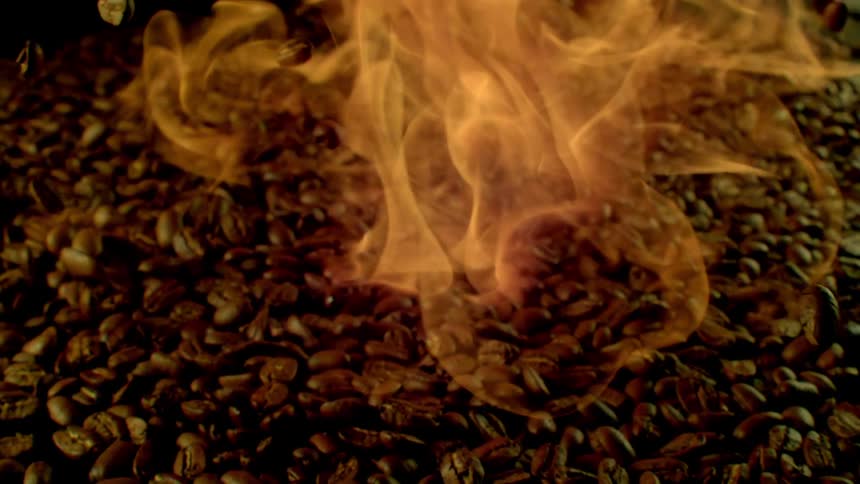 A huge pile of coffee with some beans falling out and smoke coming out of the pile